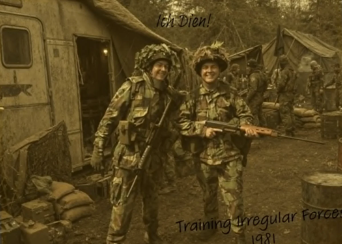 Two smiling soldiers in disruptive-pattern camouflage and foliage-covered helmets stand together in a camp of tents and a trailer, sandbags and ammunition crates around them, more troops behind. Handwritten above: Ich Dien! Below: Training Irregular Forces 1981.